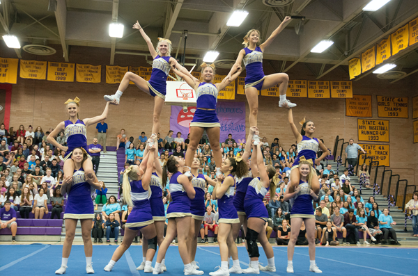Cheerleaders form a pyramid during assembly.