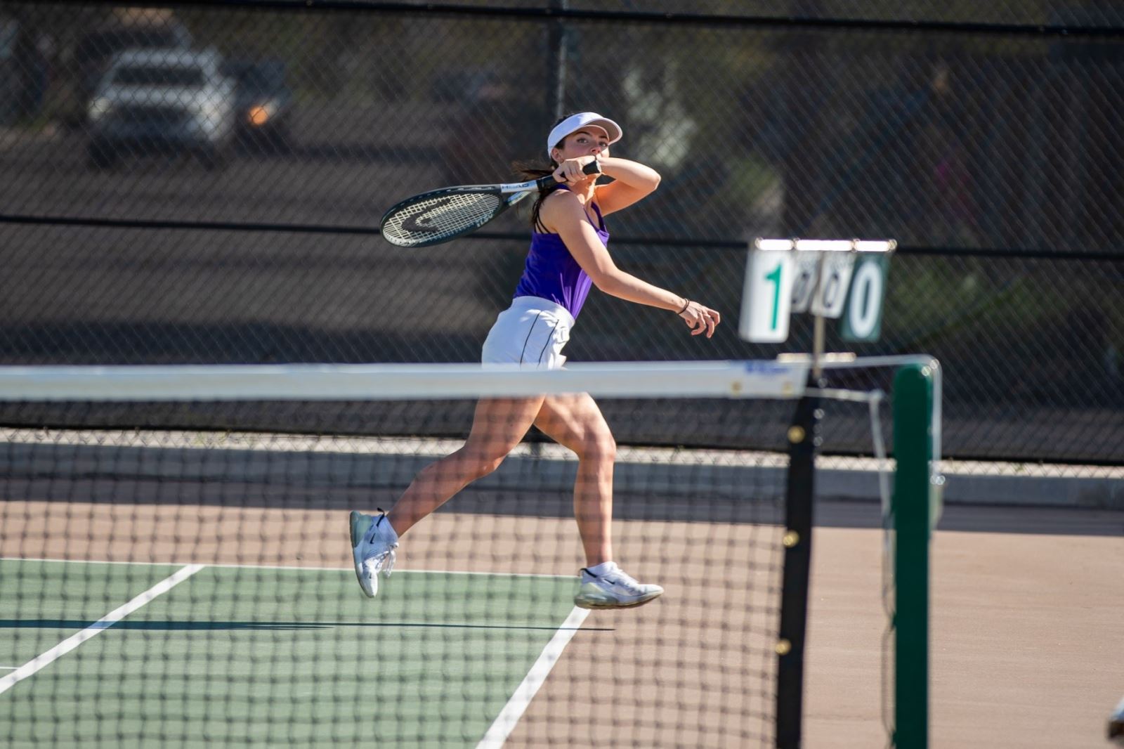 A Sabino girls tennis player aims her racquet over her shoulder to hit the ball