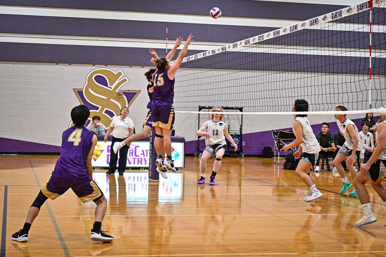 Sabino players spike the volleyball over the net