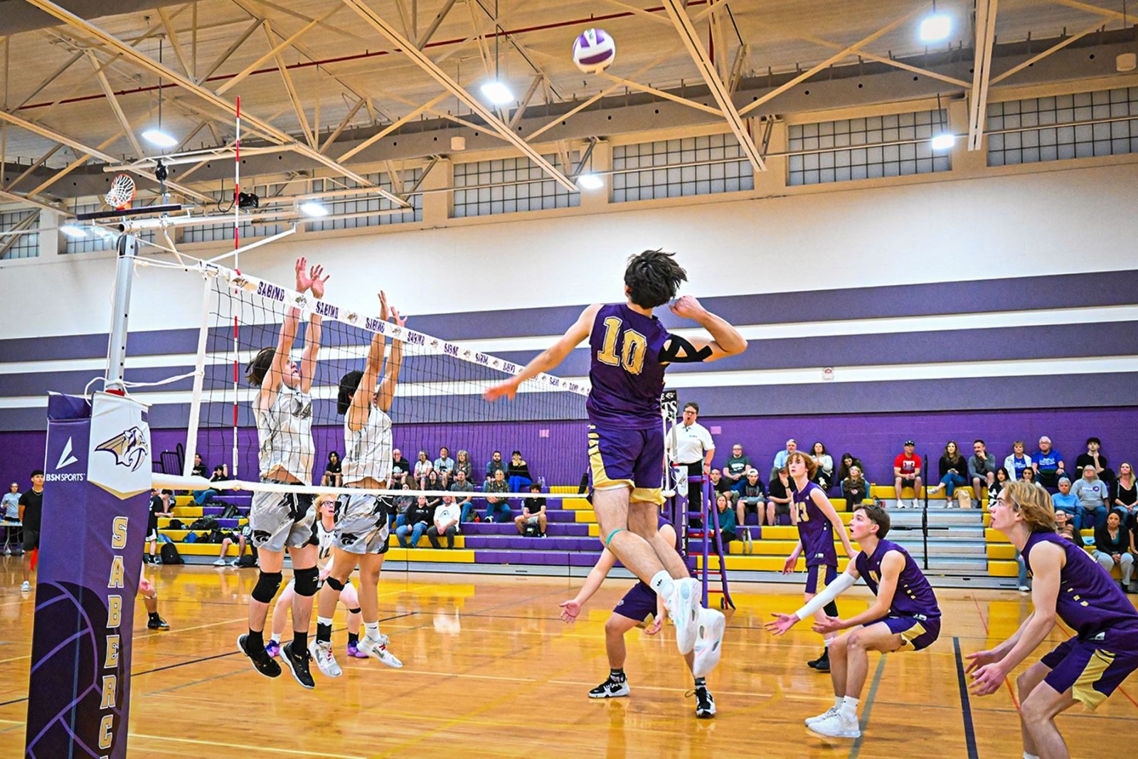A Sabino player spikes the ball over the net