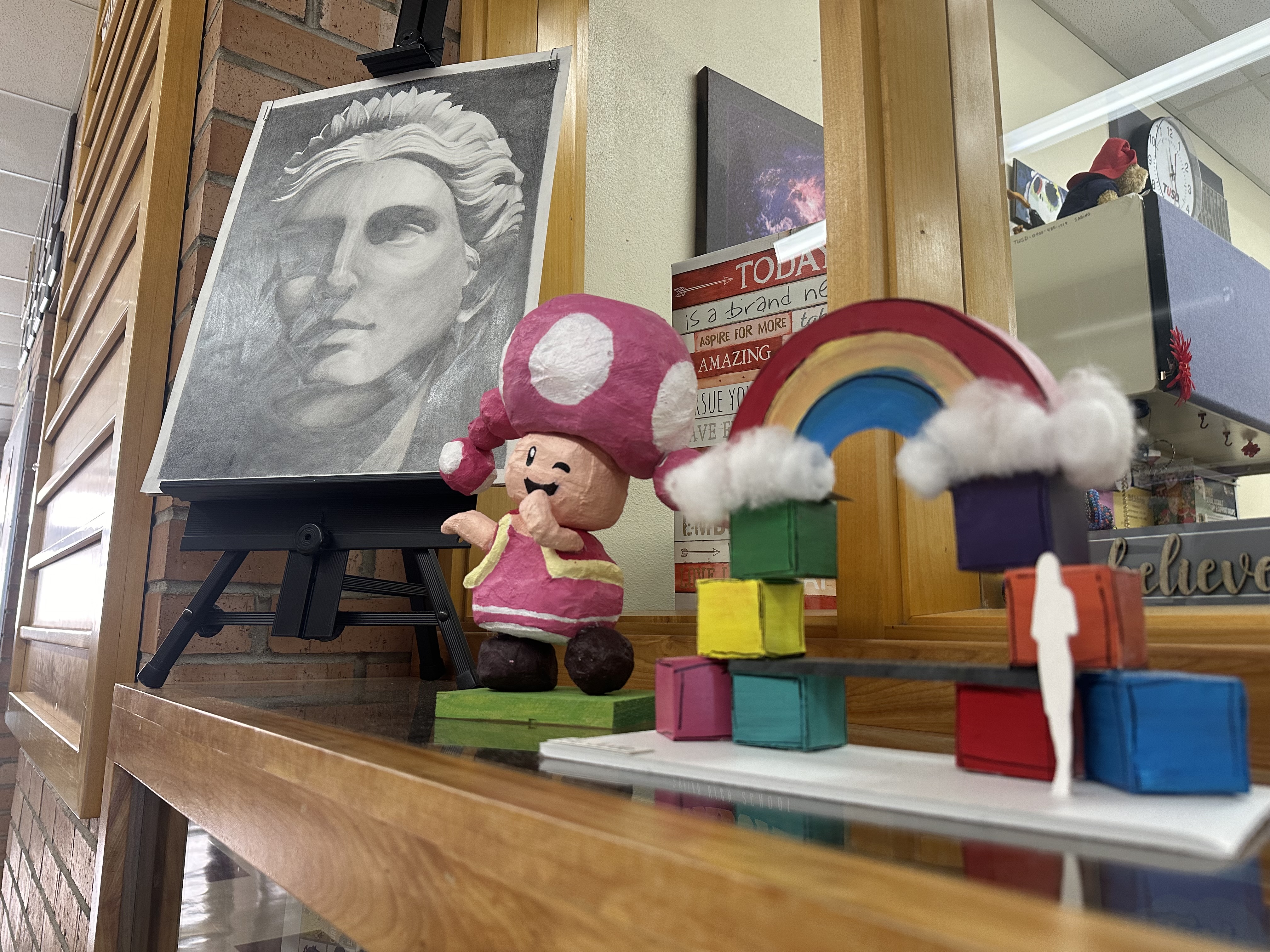 Student-created sculptures of a cartoon character and rainbow