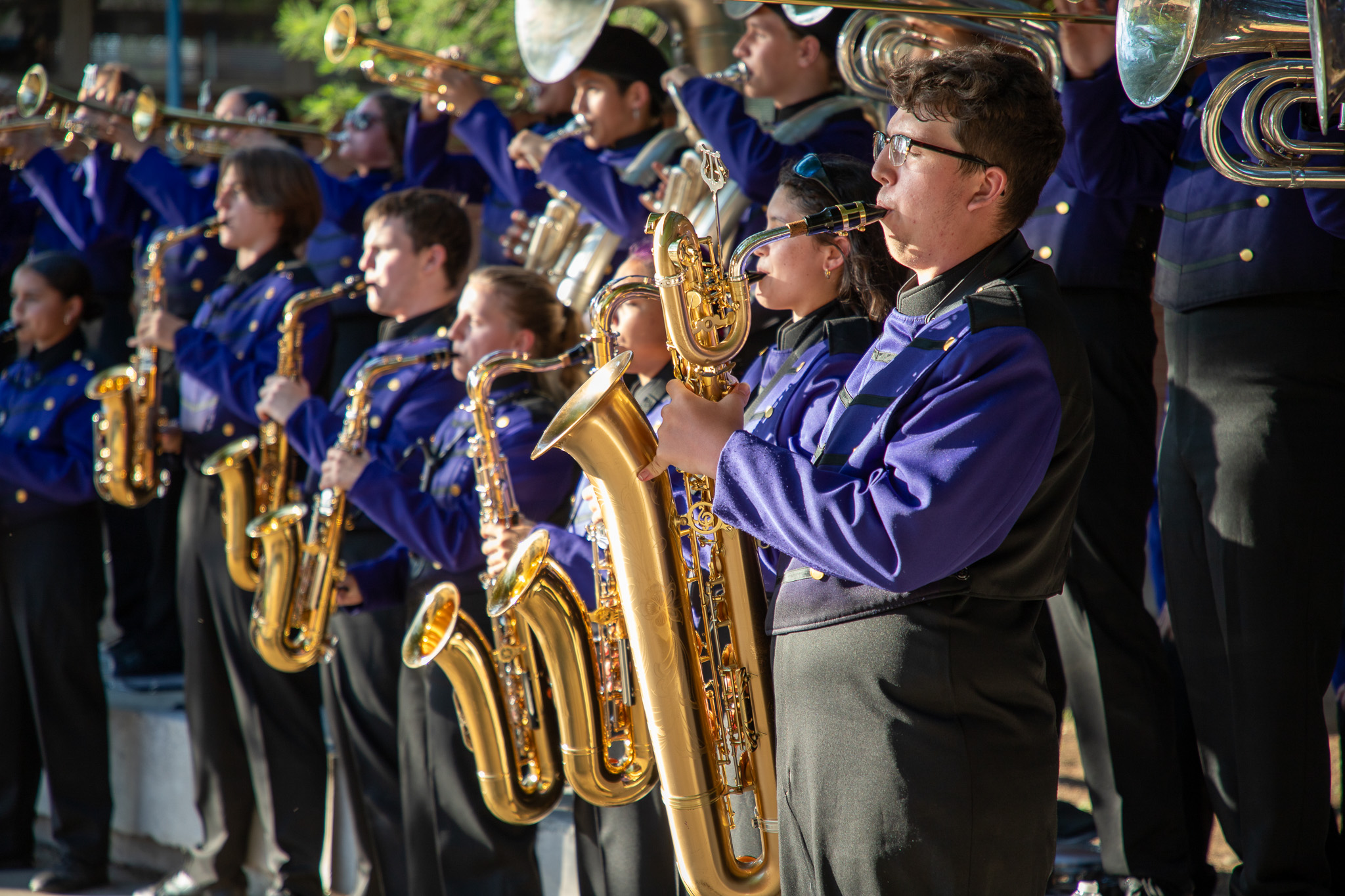 Saxophonists perform with the marching band