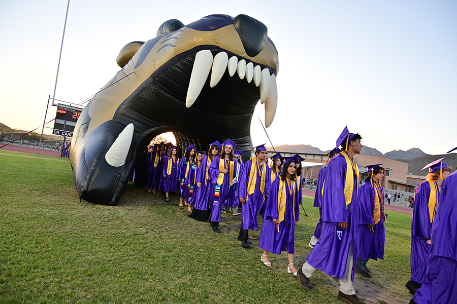 Graduating seniors walk through the inflatable sabercat head
