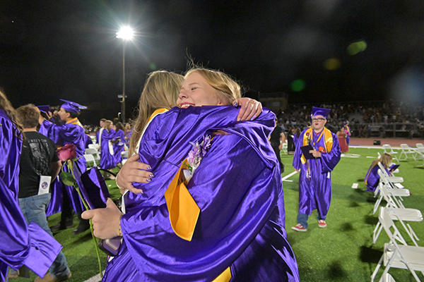 Two graduates hug each other