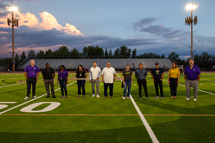 A group of people stand in the middle of a football field