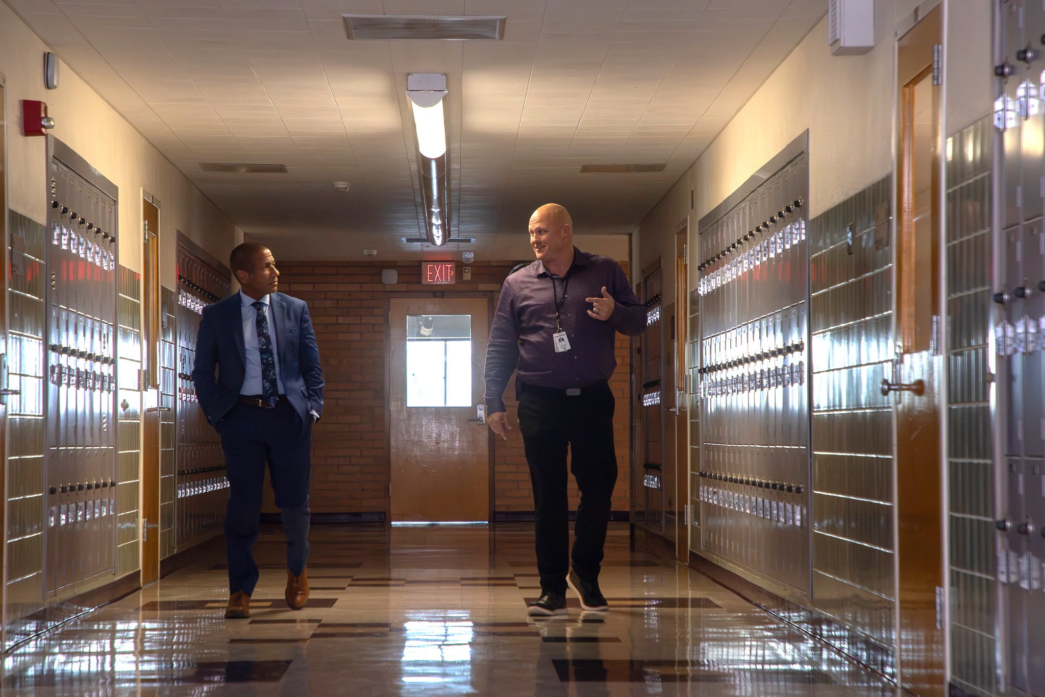 Dr.Trujillo and Sabino's principal walk down a school hallway
