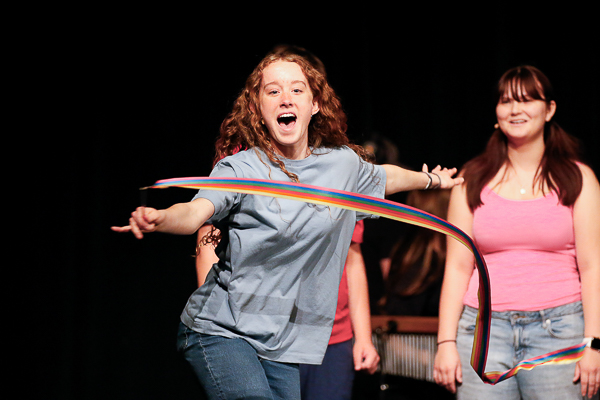 A performer spins a ribbon and exclaims
