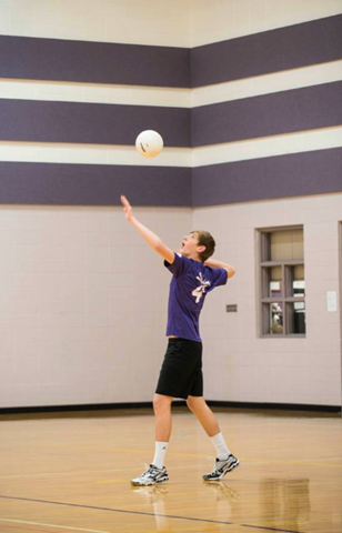 Student hitting volleyball during match