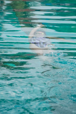 Student swimming in pool during swim team