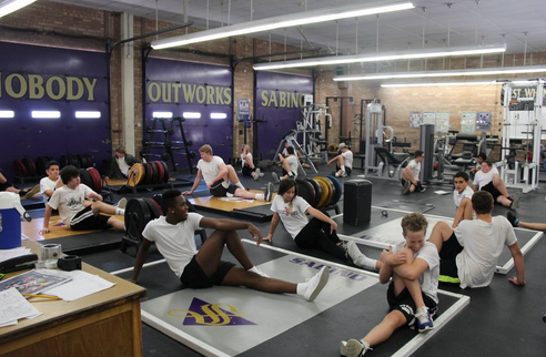 The Students Stretch In Weight Training.